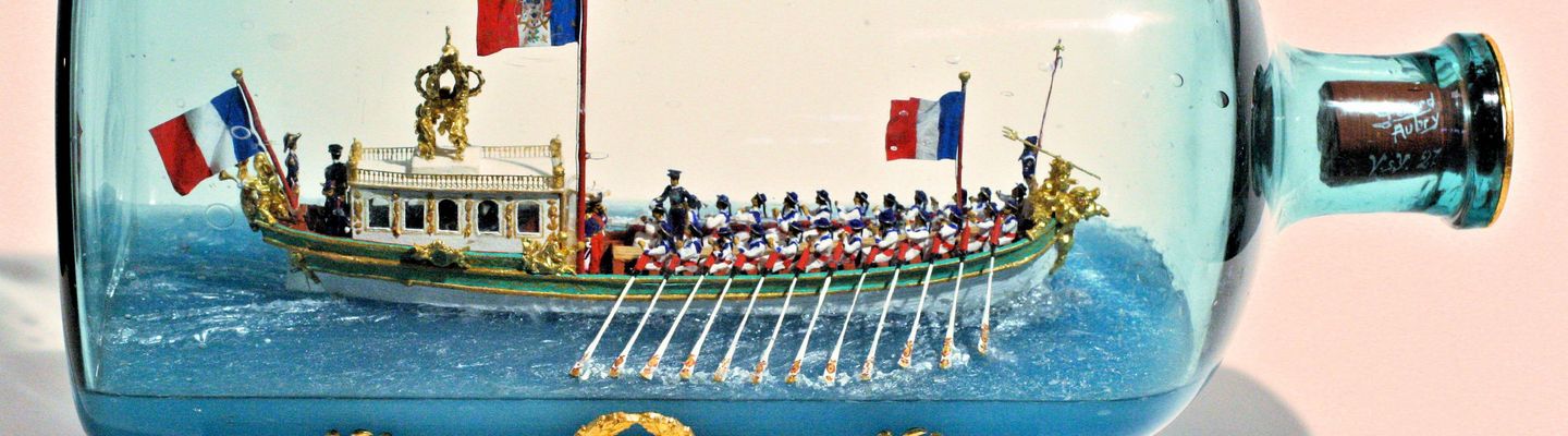 Maquette du canot impérial de Napoléon Ier réalisée dans une bouteille en verre, avec rameurs et pavillons français.