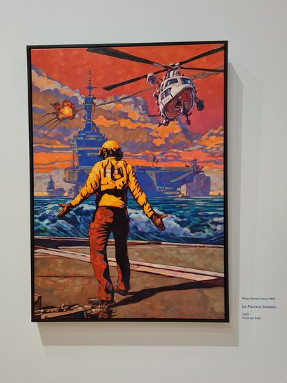 Tableau « Le Facteur humain » de Miles Hyman (2025, huile sur toile) : un marin en combinaison jaune, bras écartés, dirige les manœuvres sur le pont d'un porte-avions, face à un hélicoptère en vol et une explosion à l'horizon sous un ciel orangé.