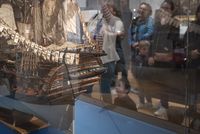 Vue d'une famille avec médiatrice depuis la vitrine d'une maquette
