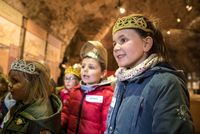 gros plan sur une petite fille avec une couronne de princesse avec d'autres enfants déguisés au second plan