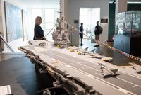 Salle du musée avec le public et une maquette actuelle 