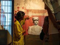 Médiatrice expliquant une œuvre représentant un buste de Pierre Loti sculpté sur fond rouge
