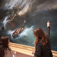 Au musée national de la Marine pendant les joyeux mercredis, un médiatrice montre à une enfant un grand tableau représentant un naufrage en mer avec un vaisseau en perdition.