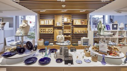 Boutique du musée national de la Marine avec comptoir central, livres et objets décoratifs autour de la culture maritime.